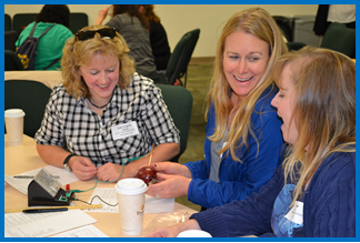 three females laughing at table